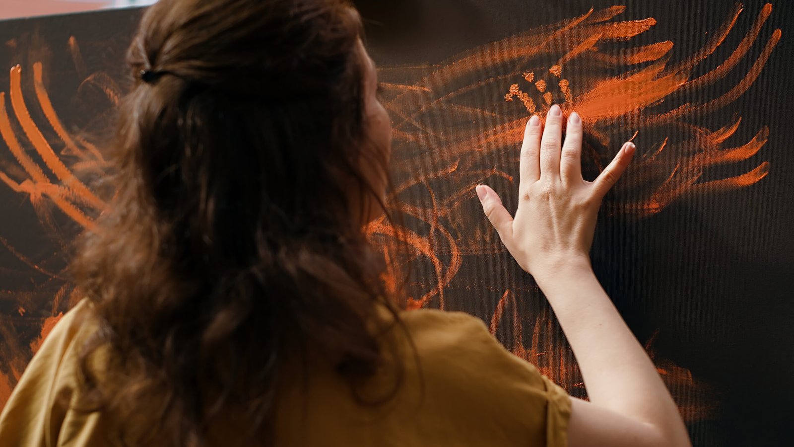 Pessoa em atividade artística diante de uma pintura